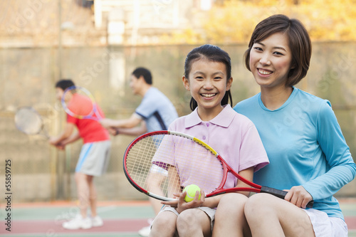 Mother and daughter playing tennis  © xixinxing