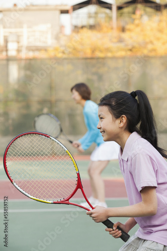 Mother and daughter playing tennis  © xixinxing