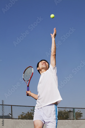Adult men serving the tennis ball 