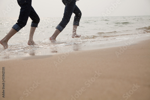 Young Couple Running in the Waves © xixinxing