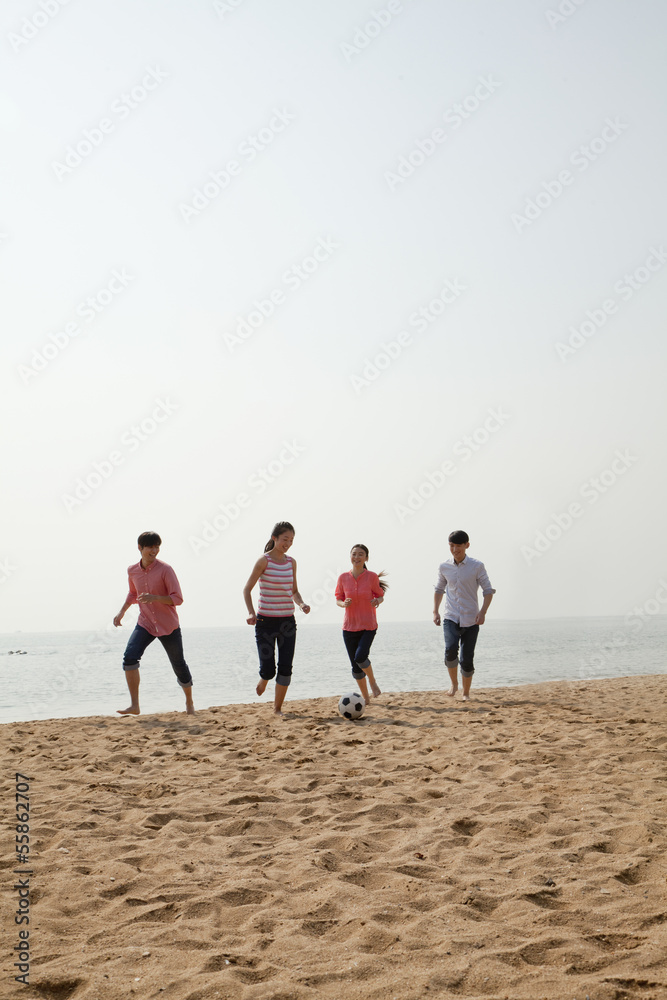 Young Friends Playing Soccer on the Beach