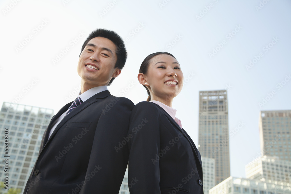 Portrait of two young business people outside in the business district, Beijing, low angle view Portrait of two young business people outside in the business district, Beijing, low angle view