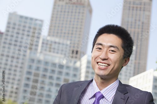 Portrait of young businessman outside in the business district, Beijing