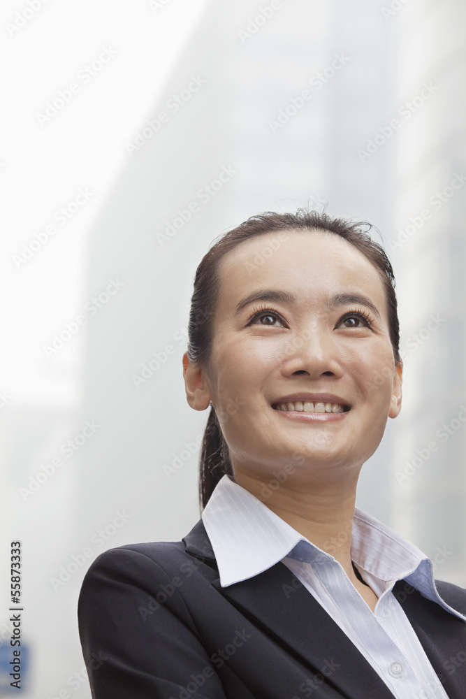 Young Businesswoman Smiling and Looking into the Distance Young Businesswoman Smiling and Looking into the Distance
