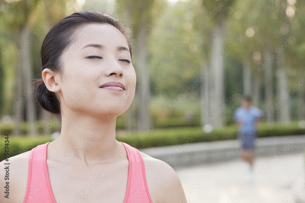 Young Woman With Eyes Closed in Park in Beijing