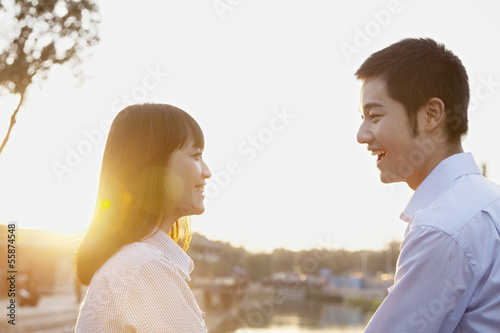 Happy Young Couple Looking at the Camera by a River