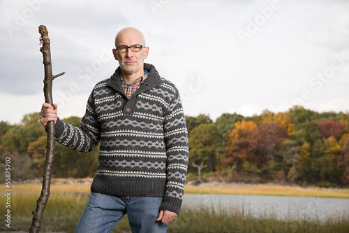 Fotografie Mature man holding a stick
