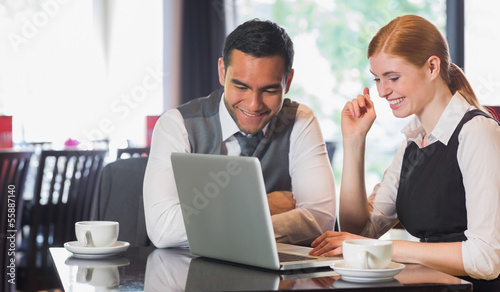 Happy business team working together in a cafe