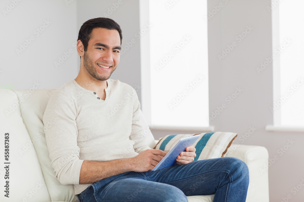 Cheerful casual man using his tablet