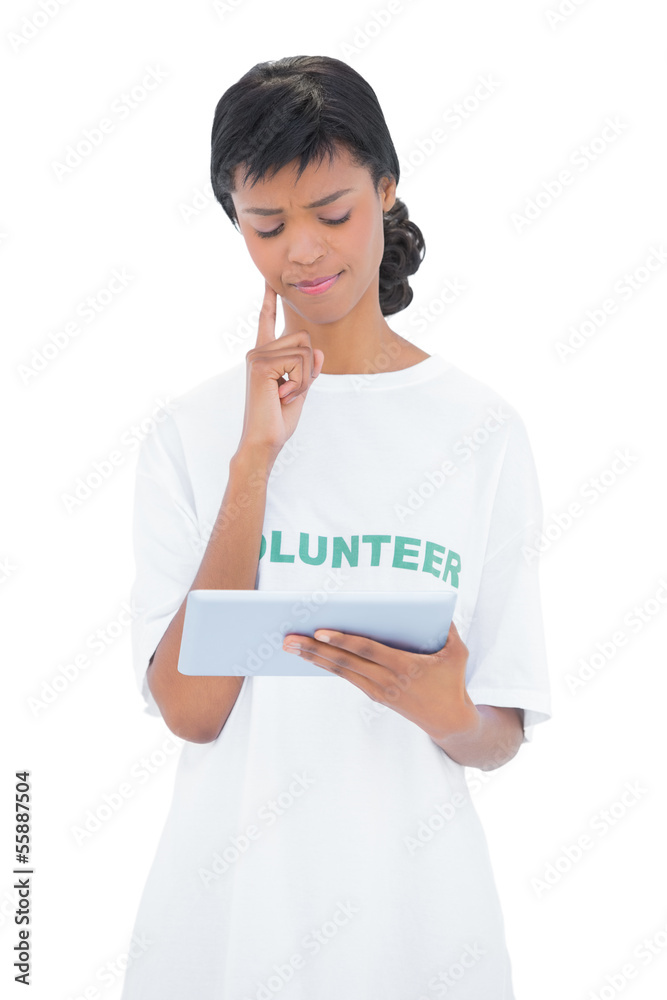 Pensive black haired volunteer using a tablet pc Pensive black haired volunteer using a tablet pc
