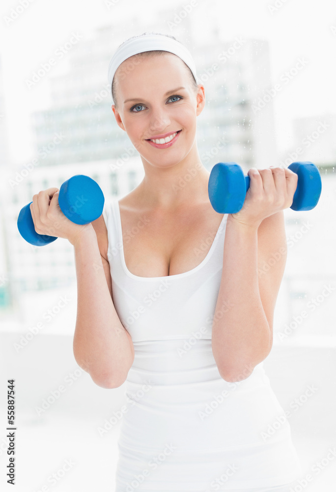 Motivated pretty sportswoman carrying dumbbells Motivated pretty sportswoman carrying dumbbells