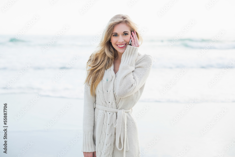 Cheerful blonde woman in wool cardigan making a phone call Cheerful blonde woman in wool cardigan making a phone call