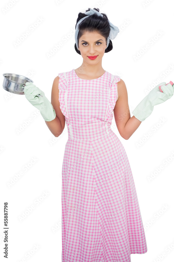 Smiling black hair model holding a pan and wearing rubber gloves Smiling black hair model holding a pan and wearing rubber gloves