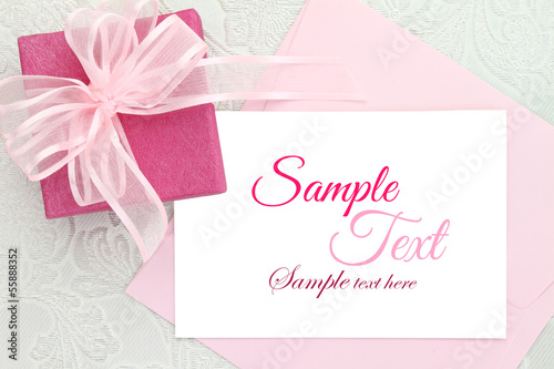 Gift box with ribbon and white invitation card © viperagp