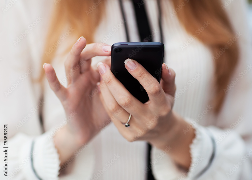 Young beautiful woman writes an SMS to your mobile phone. Young beautiful woman writes an SMS to your mobile phone.