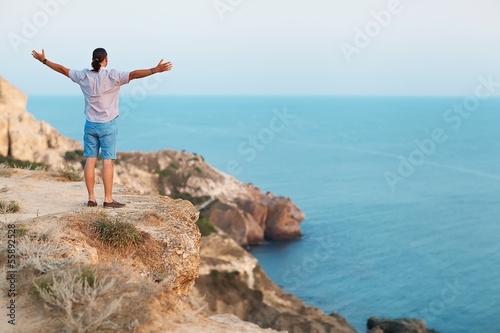 Man standing on a rock by the sea . Concept of freedom. 