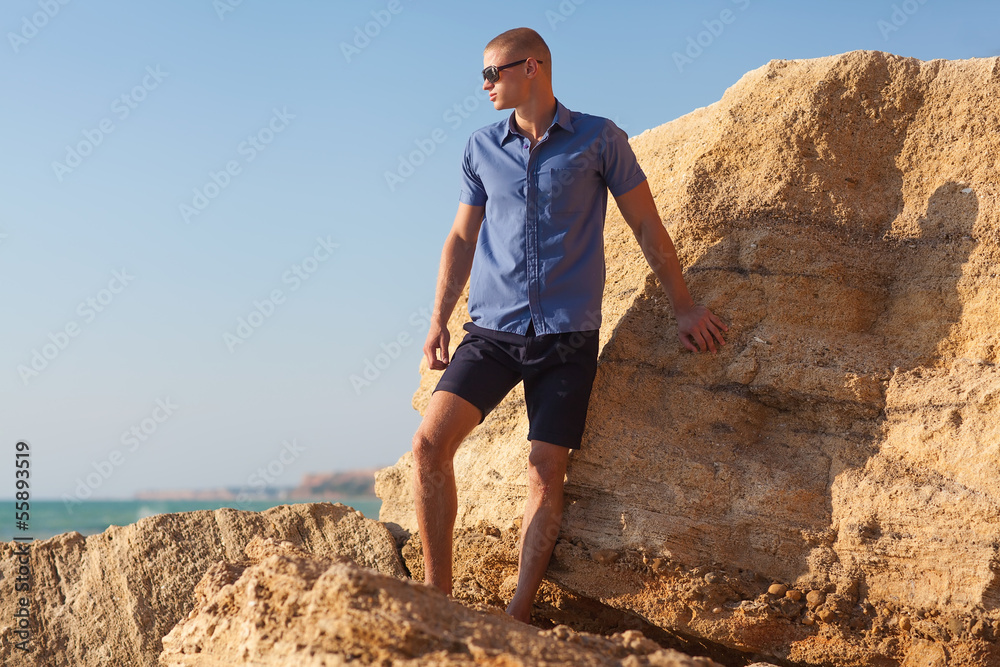 Young, fashion, muscular man standing on the beach. Young, fashion, muscular man standing on the beach.