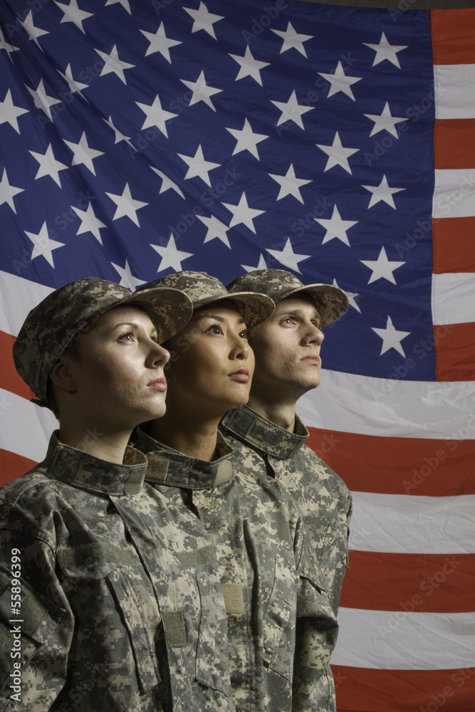 Three young military personnel in front of flag, vertical Three young military personnel in front of flag, vertical