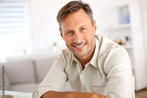 Attractive smiling man relaxing at home photo