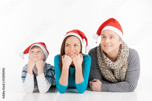Family on Christmas. Cheerful family in Santa hats looking away