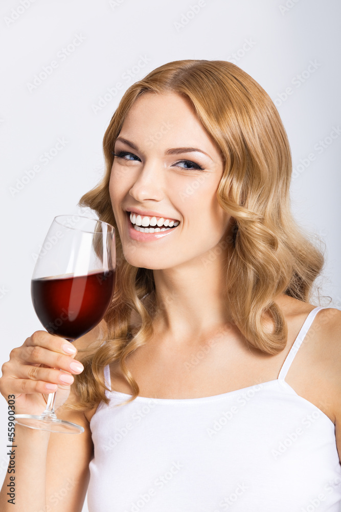 Young happy woman with glass of redwine, on gray Young happy woman with glass of redwine, on gray