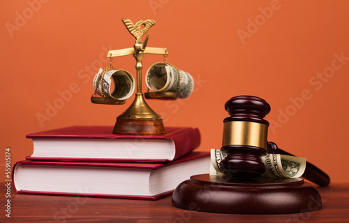 judge gavel,dollar money and scales of justice on table