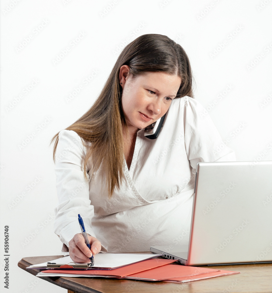 Pregnant Young Woman on Phone at Laptop at Work or Home Pregnant Young Woman on Phone at Laptop at Work or Home