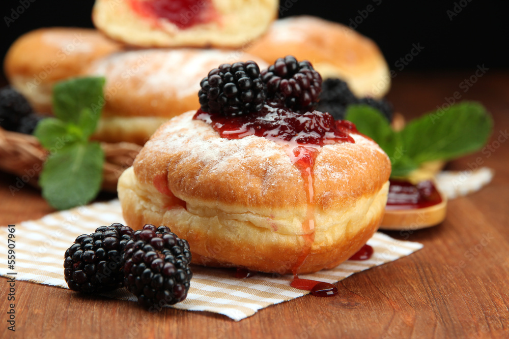 Tasty donuts with berries on wooden table Tasty donuts with berries on wooden table