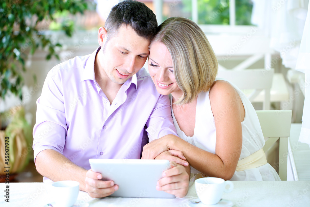 Young couple taking photo with tablet in restaurant Young couple taking photo with tablet in restaurant