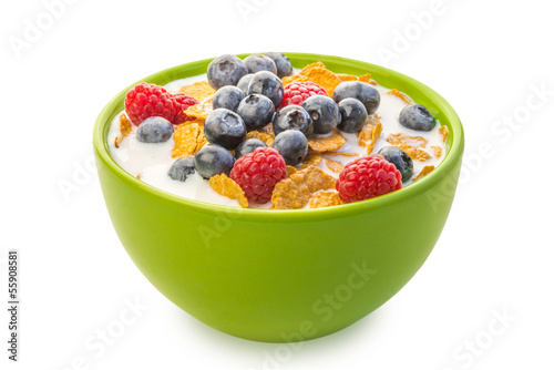 A bowl of cereals with blueberries and raspberries with milk