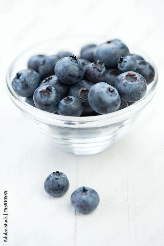 Glass dish with freshly picked blueberries, vertical shot Glass dish with freshly picked blueberries, vertical shot