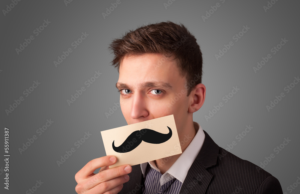 Happy businessman holding funny mustache card on his mouth Happy businessman holding funny mustache card on his mouth
