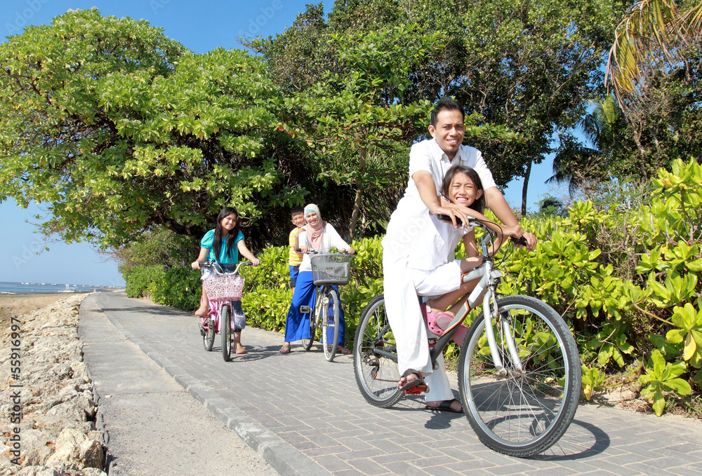 Fototapeta premium Happy asian family riding bikes in the beautiful morning at the