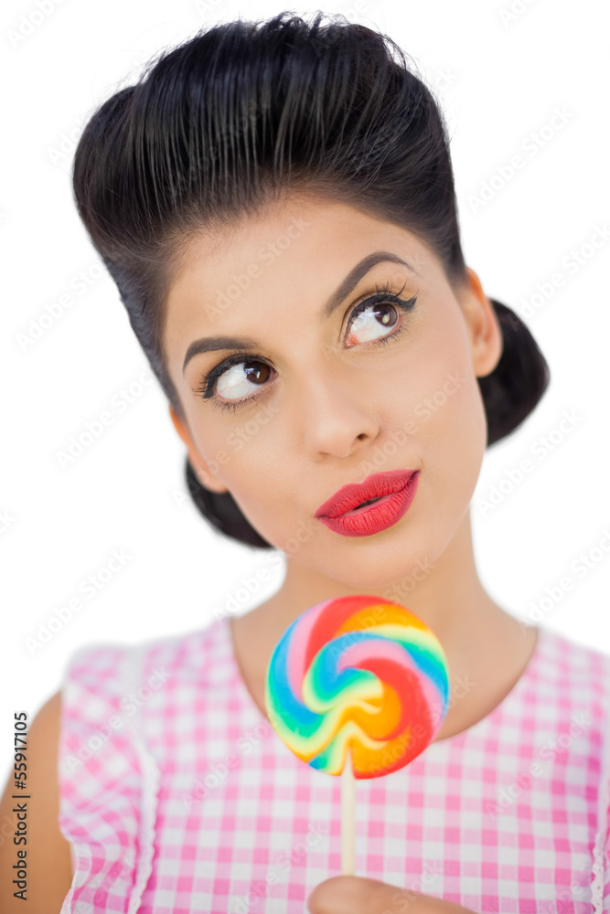 Wondering black hair model holding a colored lollipop Wondering black hair model holding a colored lollipop