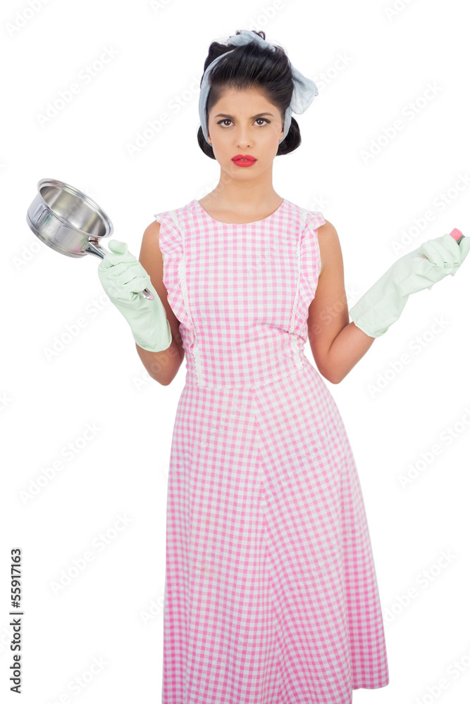 Disppointed black hair model holding a pan and wearing rubber gl Disppointed black hair model holding a pan and wearing rubber gl