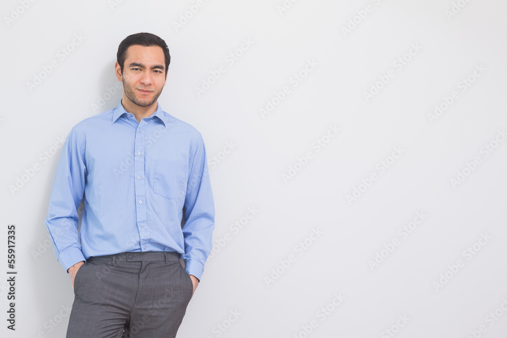 Fototapeta premium Content man leaning against a wall hands in the pockets
