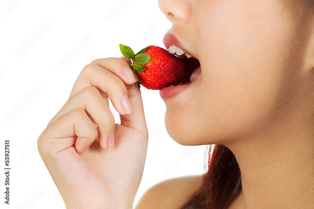 Young Asian woman bites strawberry Young Asian woman bites strawberry