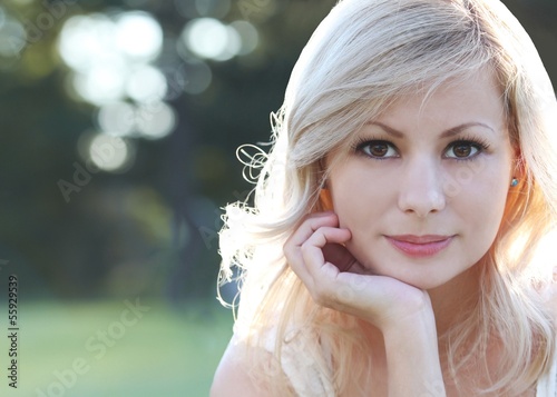 Smiling blonde girl. Portrait of happy woman. Bokeh