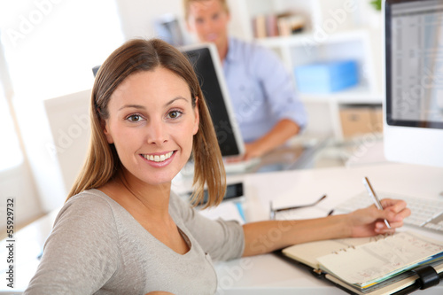 Young businesswoman sitting at desk in office