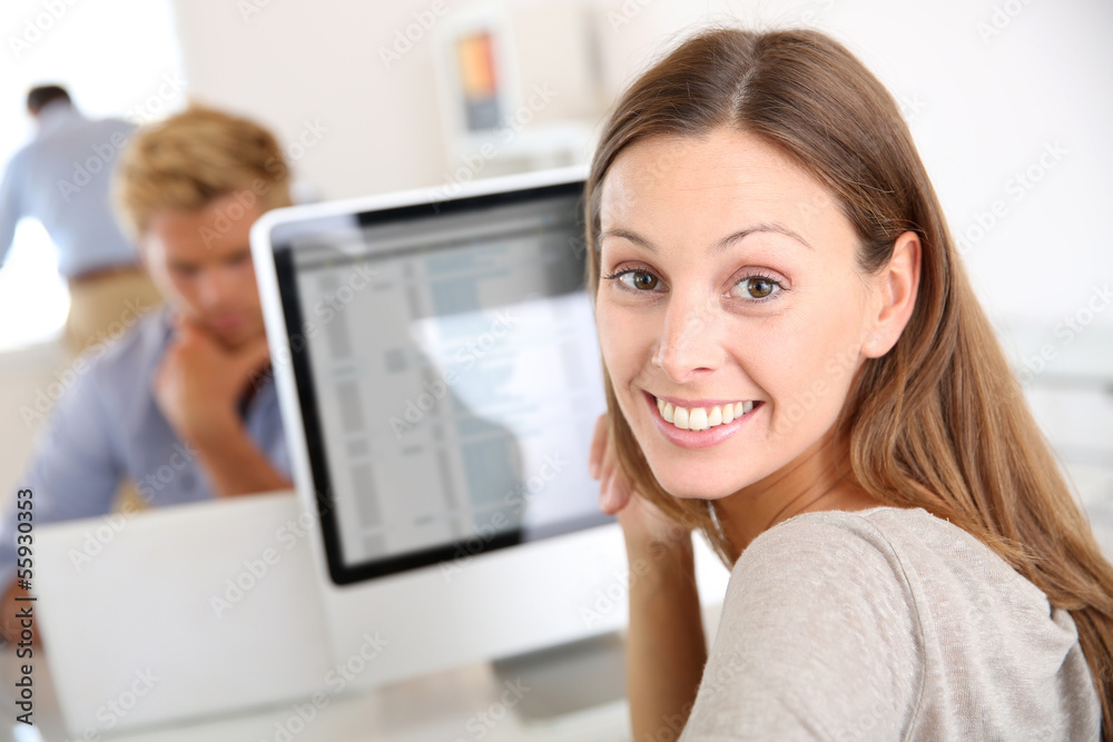 Portrait of smiling office worker in front of desktop Portrait of smiling office worker in front of desktop