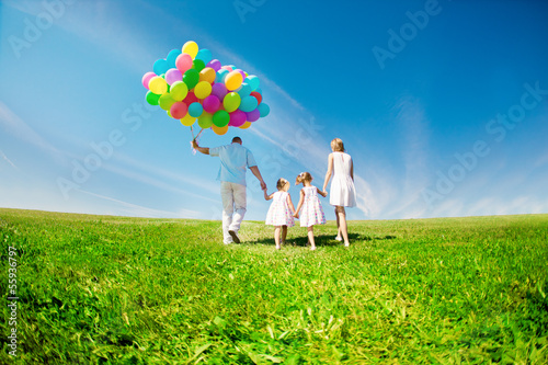 Happy family holding colorful balloons. Mom, dad and two daughte photo