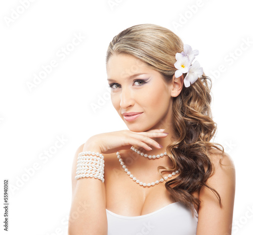 Portrait of a beautiful woman with a pearl jewelry and a flower