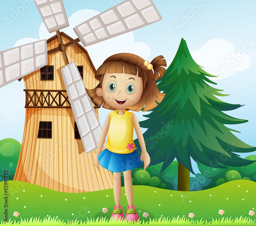 A young girl near the farmhouse with a windmill