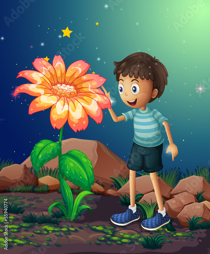 A young boy beside the giant flower