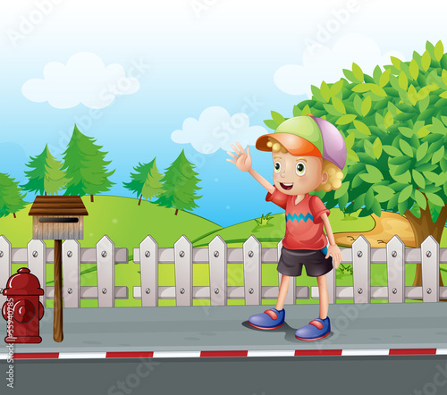 A young boy waving near the mailbox at the road