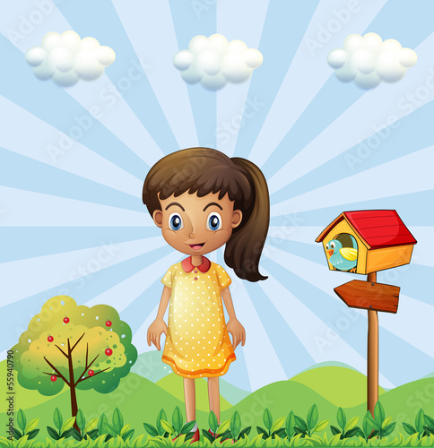 A young girl with a yellow dress standing near the pethouse