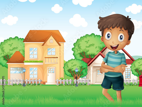 A smiling boy standing in front of the neighborhood