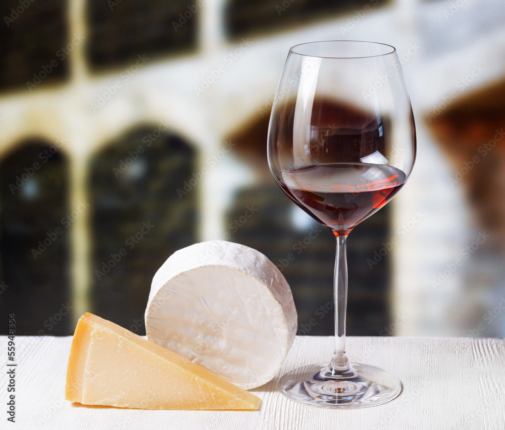 Glass of wine and wooden barrels in winery Glass of wine and wooden barrels in winery