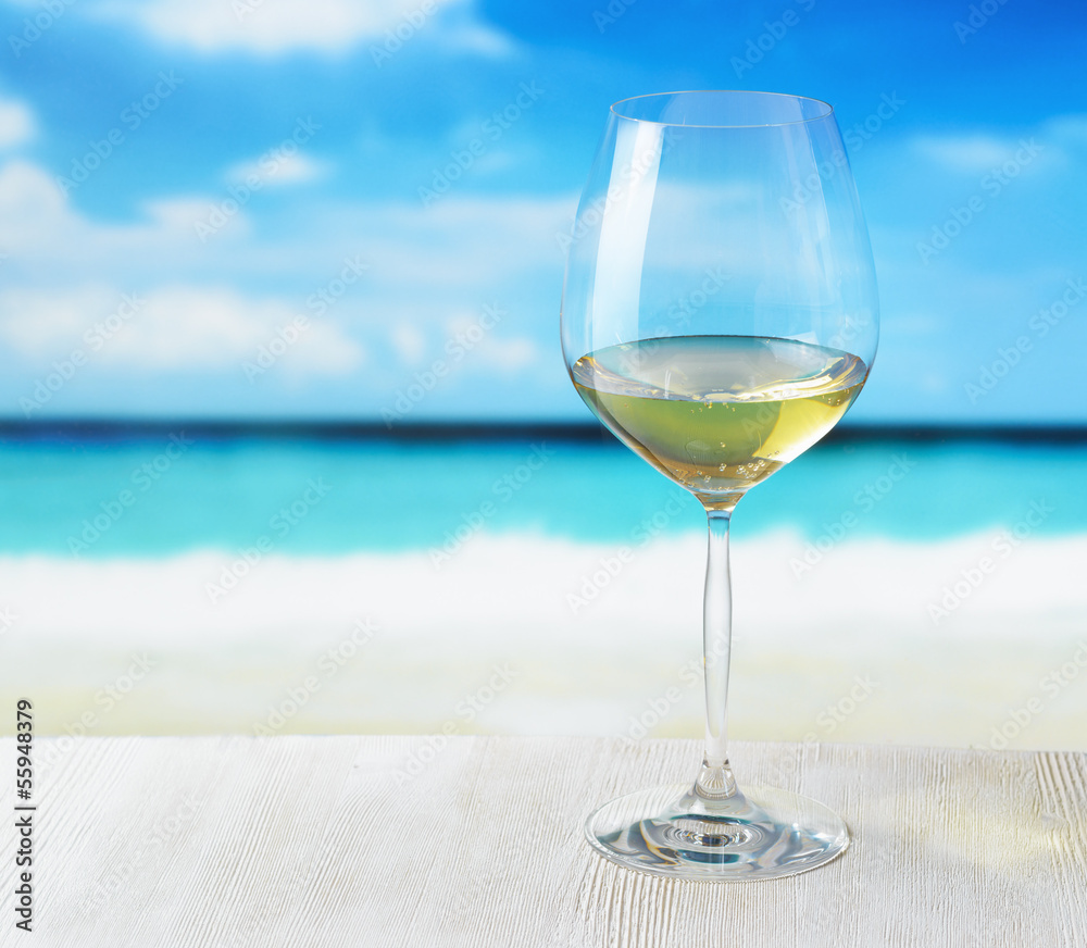 Obraz premium Glass of wine on beach background