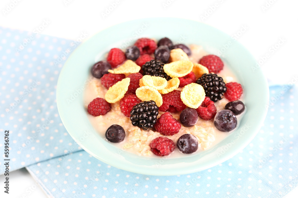 Oatmeal in bowl with berries isolated on white